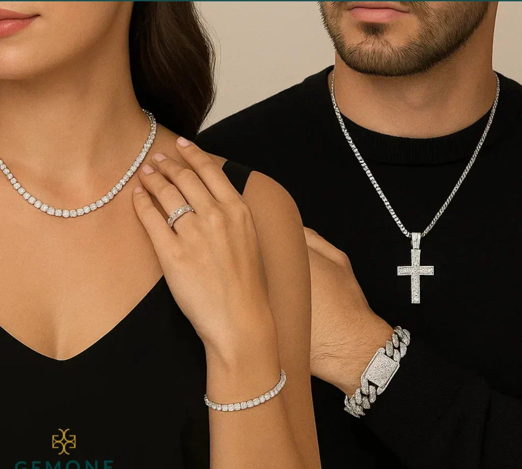 A couple wearing diamond jewelry. The woman showcases a diamond necklace, bracelet, and ring, while the man wears a diamond cross pendant necklace and bracelet.