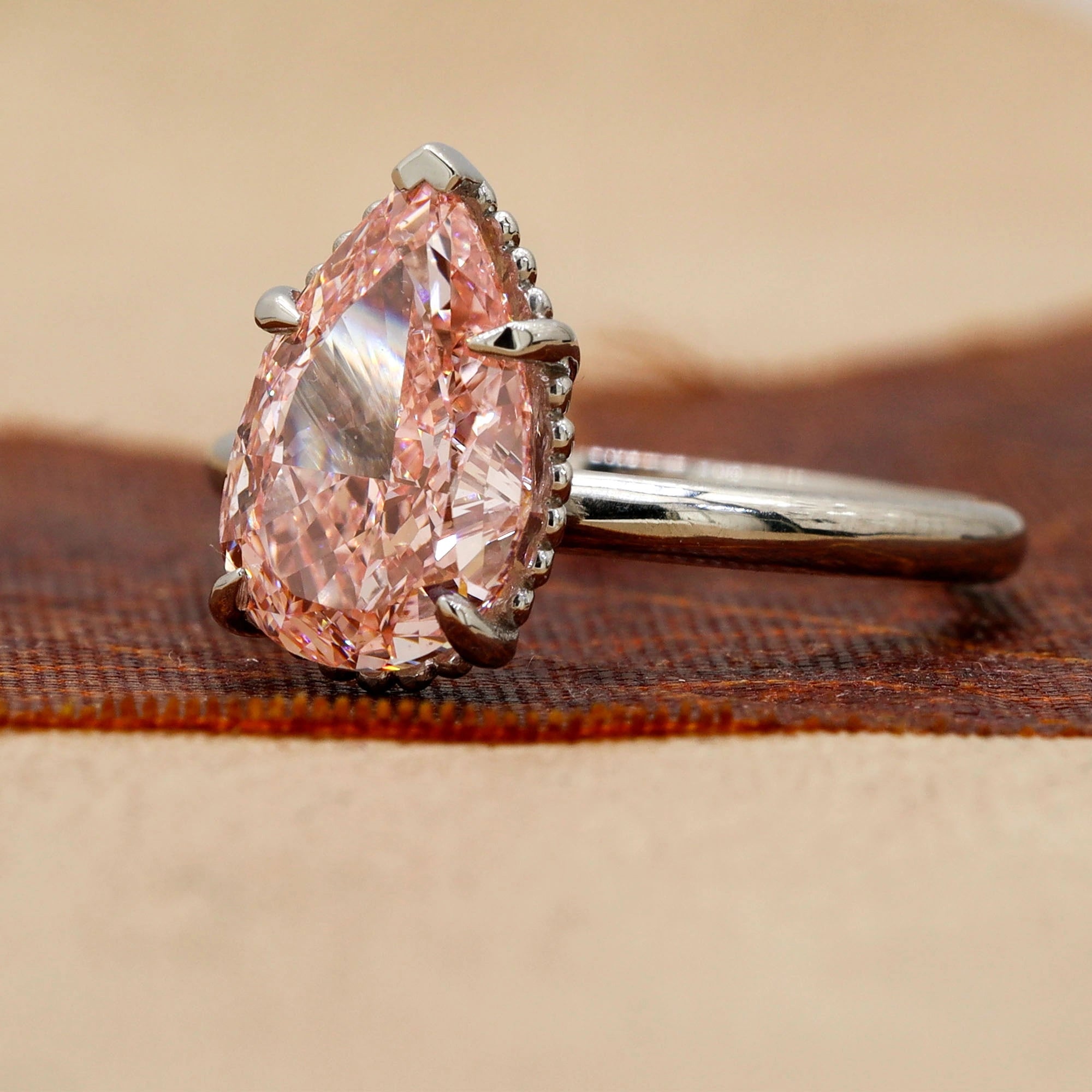 Angled view of 3 Carat Pink Pear Cut Diamond Solitaire Ring with Plain Band in Prong Setting